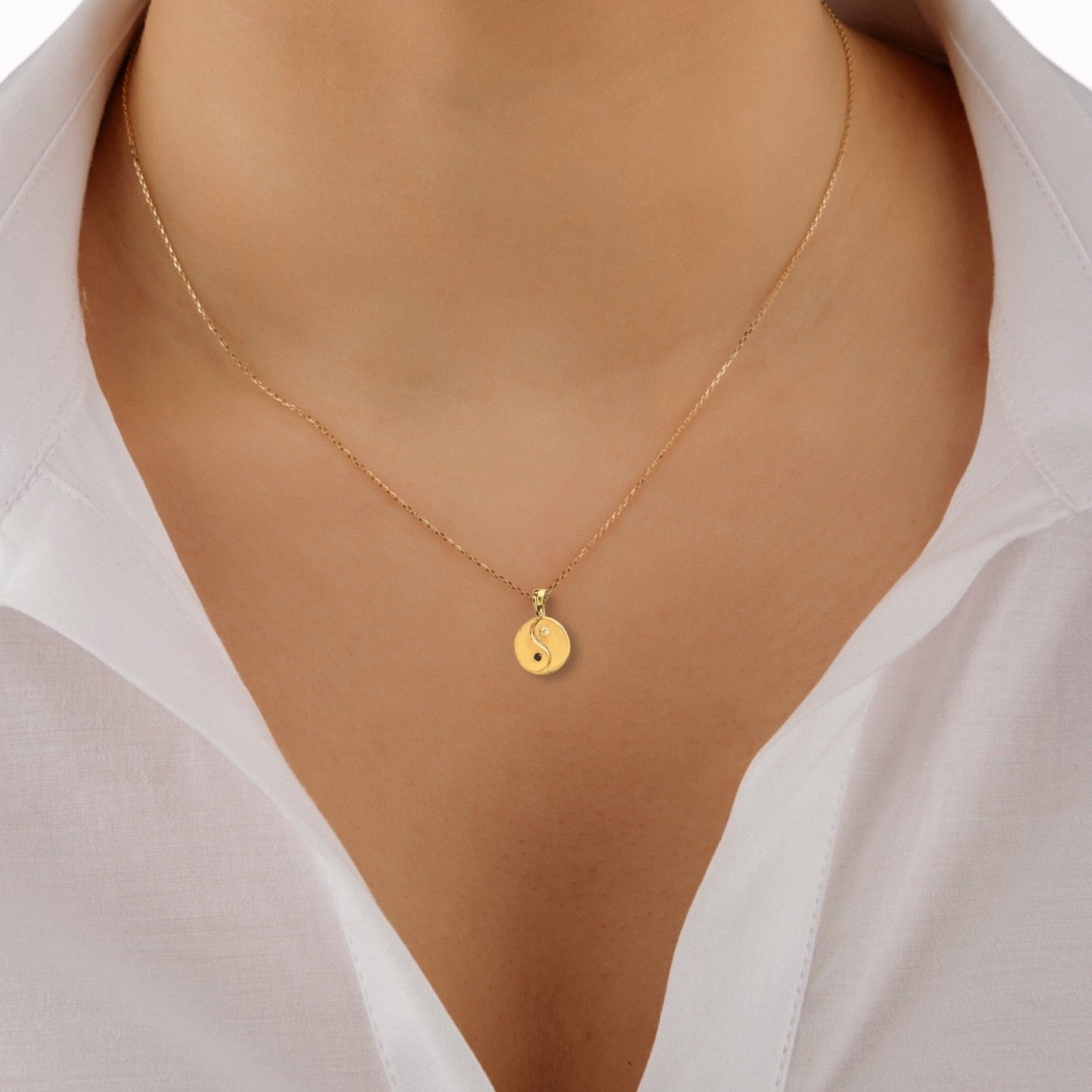 Makrub.wearitbecomeit Metalic gold coin necklace with a symbol of Yin Yang on a model